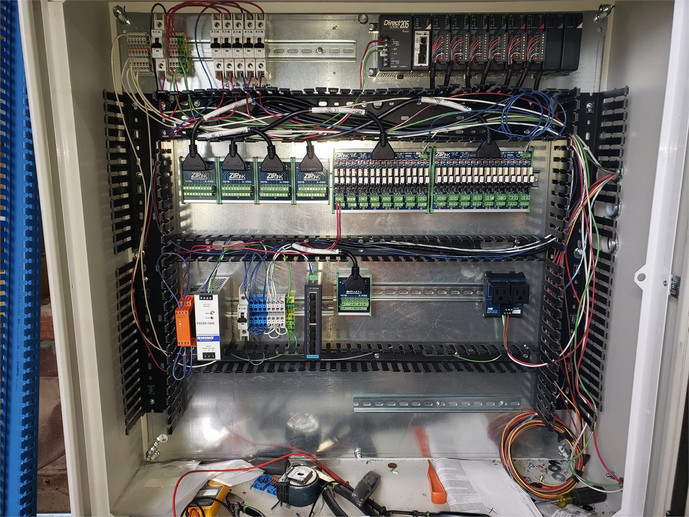 PLC automation panel with industrial controls, relays, and organized field wiring